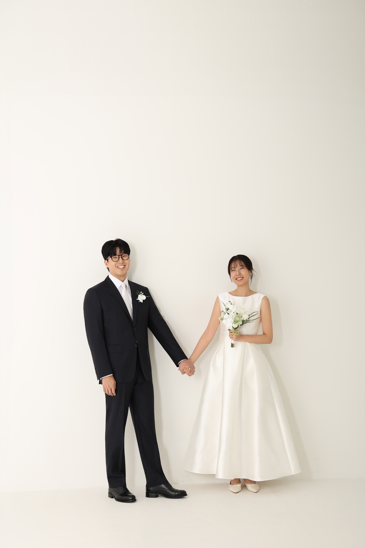 서로 손을 잡고 나란히 서 있는 두 사람